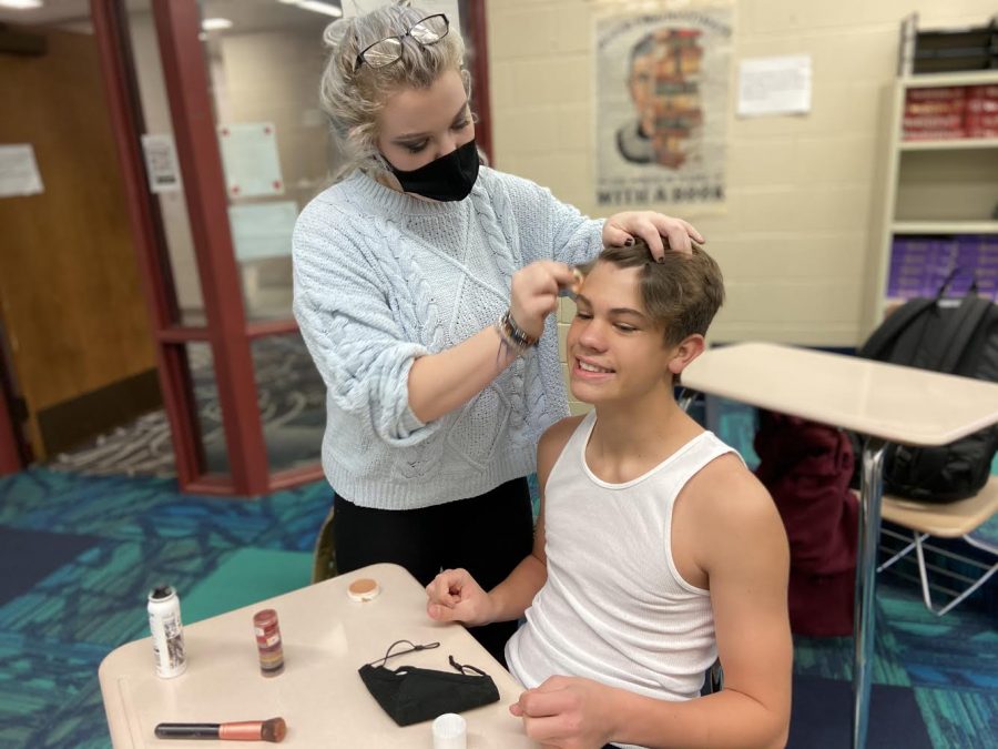 Bella Basino applies makeup to Trace Widler prior to Conestogas performance at the Nebraska Capitol Conference. Widler, a senior, plays Rex in the play No Problem.