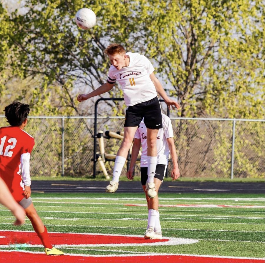 Defender Koby Vogler soars through the air as he heads a ball against Platteview.