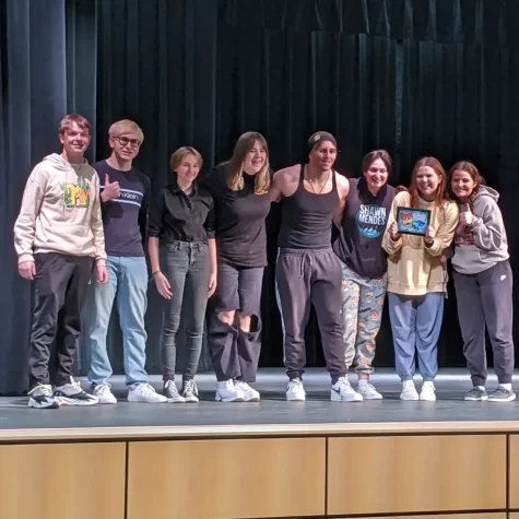 The one act seniors stand on stage after receiving their first place award