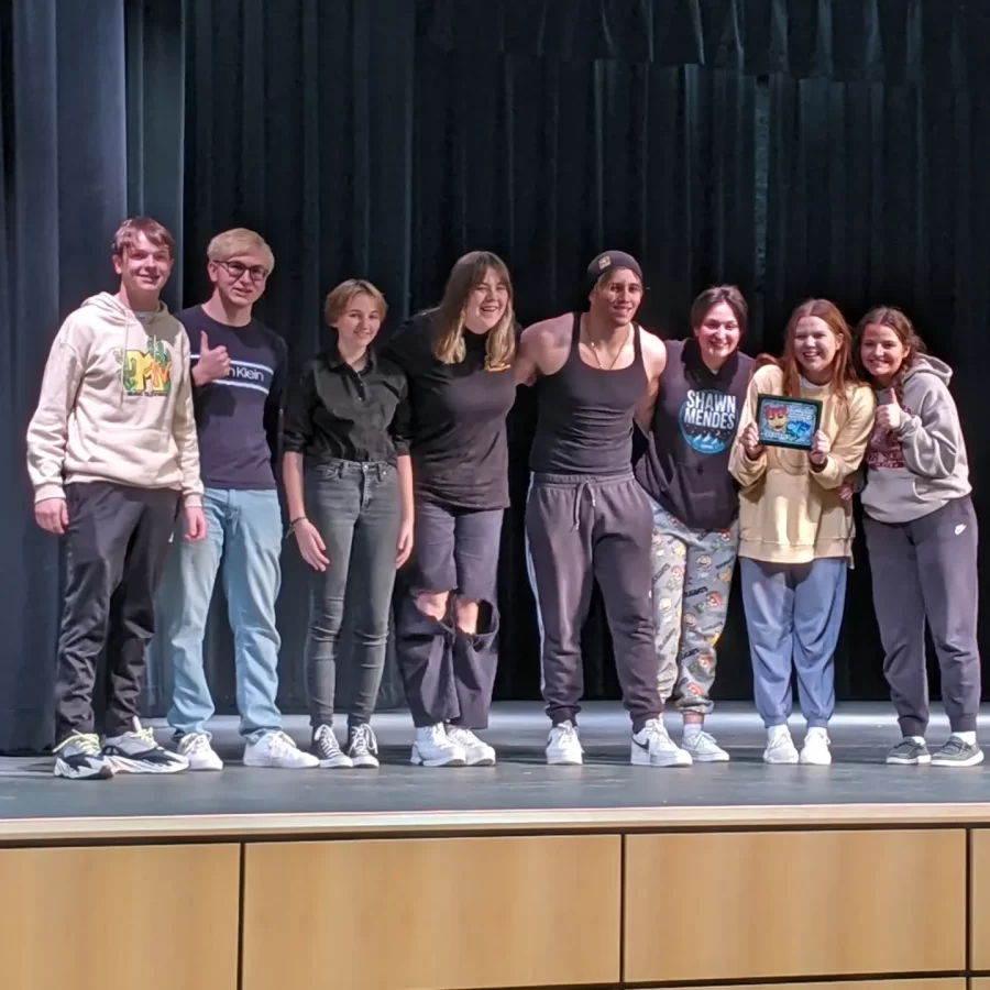 The one act seniors stand on stage after receiving their first place award