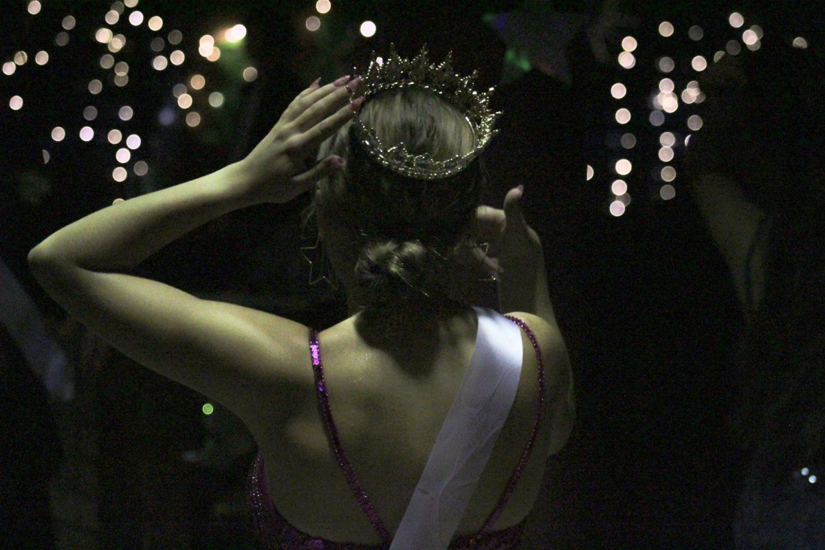 Queen Dani A Adjusts her crown.